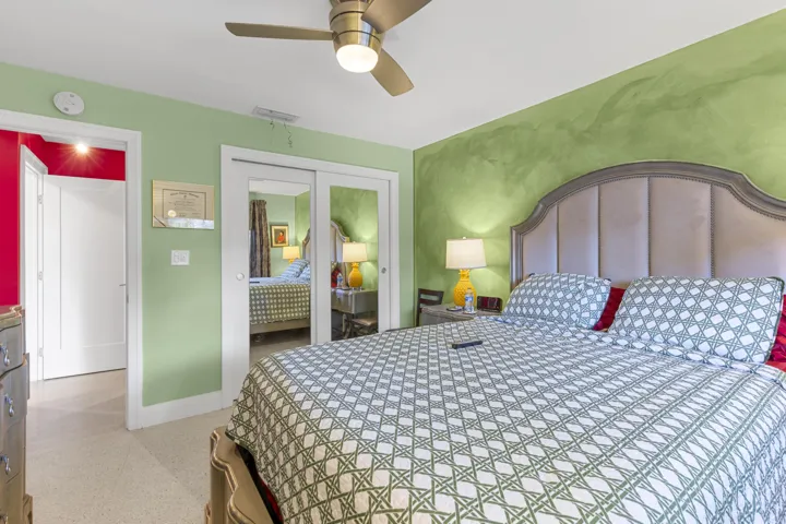 Room featuring a brushed-finish metal ceiling fan with integrated lighting, dual sliding mirrored closet doors, and solid-core interior doors