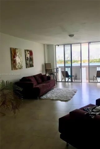 Large-format tile flooring, expansive floor-to-ceiling glass sliding doors, and private balcony access