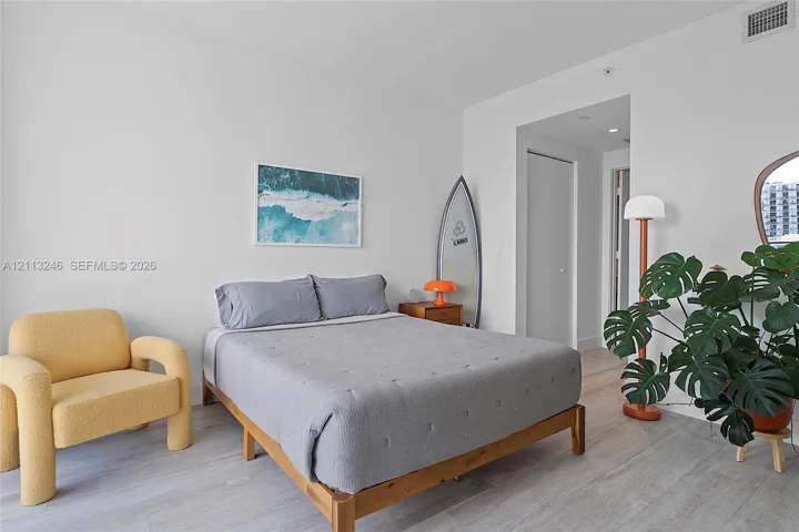 Neutral-toned wood-finish flooring, crisp white walls, and recessed ceiling lighting