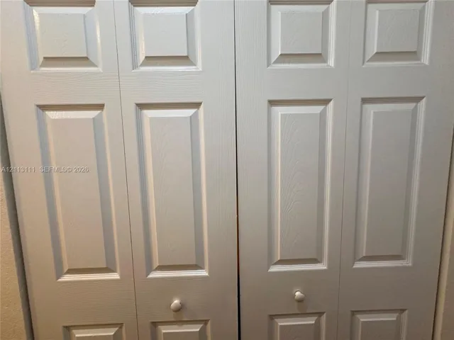 Bi-fold closet doors featuring a multi-panel design with a white finish and circular knobs