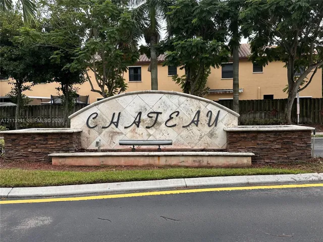 Community entrance monument featuring a stone-clad base, decorative tile facade, and integrated landscaping