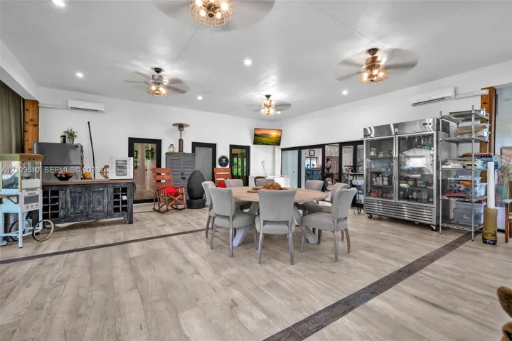 Open-concept area featuring wood-finish flooring, recessed lighting, multiple ceiling fans, and two wall-mounted ductless climate control units