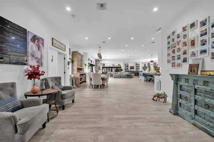 Open-concept interior featuring light wood-finish flooring, recessed lighting, and high ceilings