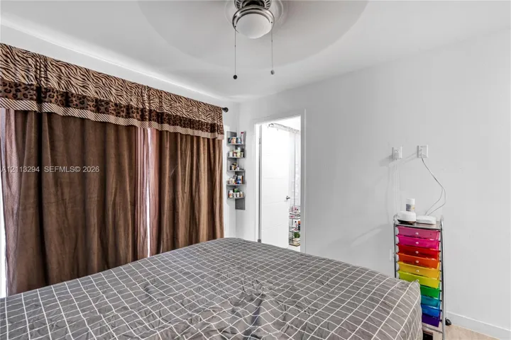 Ceiling-mounted light fixture with integrated fan, wall-mounted corner shelving unit, and recessed doorway