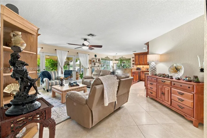 Open-concept interior featuring large-format tile flooring, recessed lighting, a ceiling fan, and sliding glass doors with direct exterior access