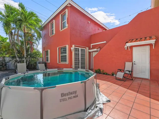 Stucco exterior featuring a tiled patio and multiple points of entry
