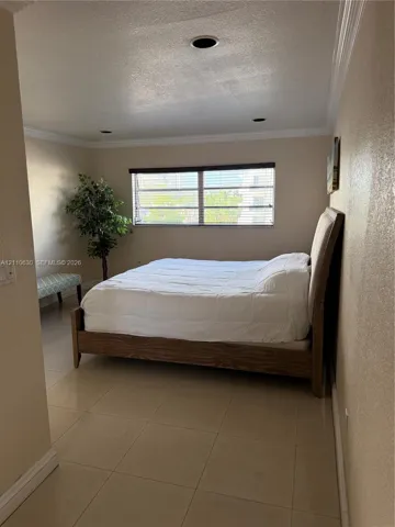 Room featuring neutral-toned walls, crown molding, tile flooring, and recessed lighting