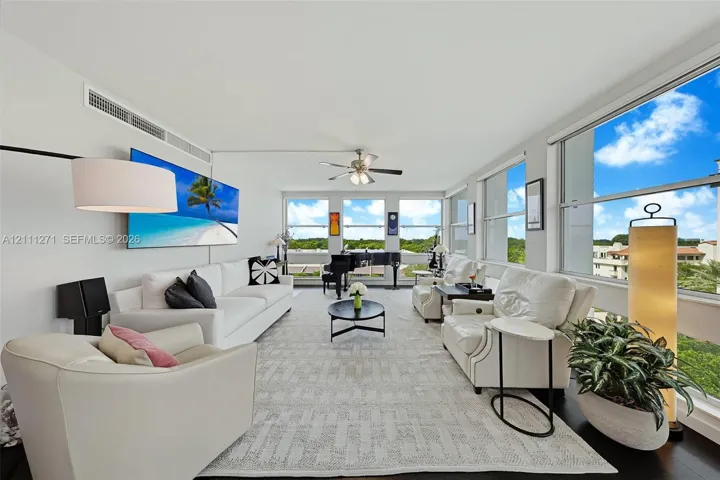 Living area featuring floor-to-ceiling windows, dark wood-finish flooring, and a ceiling fan with integrated lighting