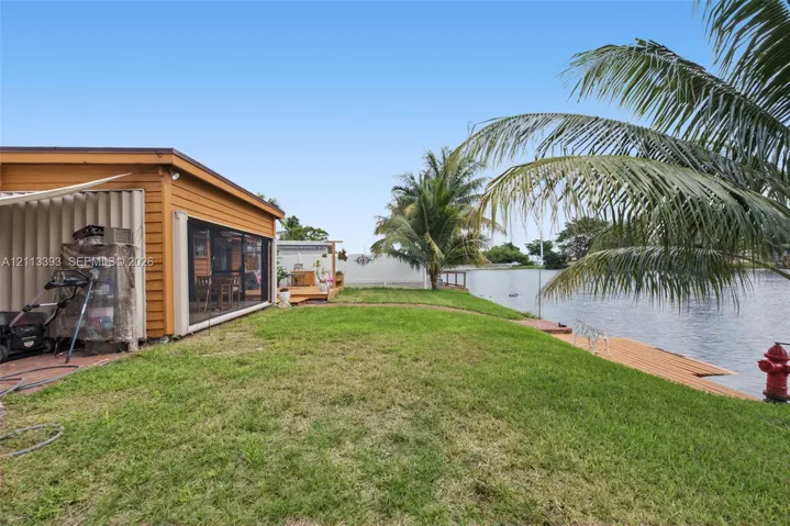 Waterfront property featuring a screened-in lanai, wood-finish siding, and a private wooden dock