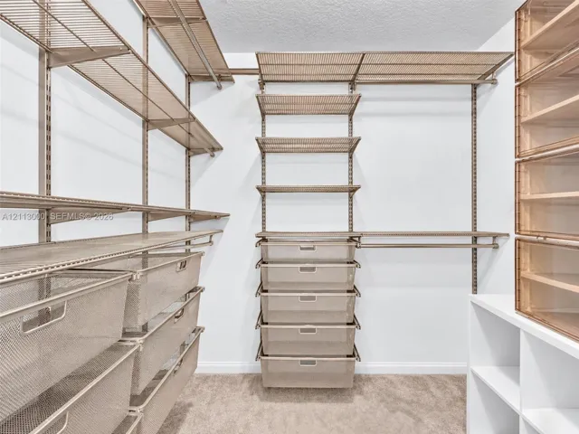 Customizable closet organization system featuring modular metal shelving, pull-out wire drawers, integrated hanging rods, and built-in tiered cabinetry