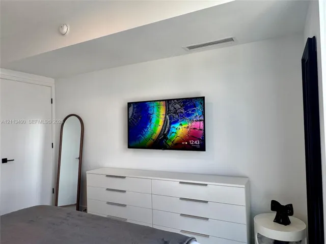 Room featuring high ceilings with recessed lighting, smooth wall finishes, and solid-core interior doors with matte black hardware