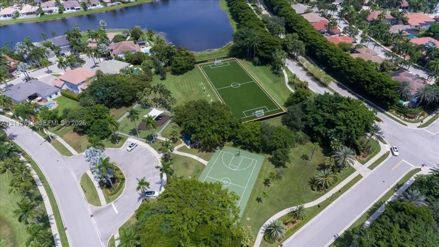 Recreational area featuring a soccer field, basketball court, paved parking, and landscaped grounds