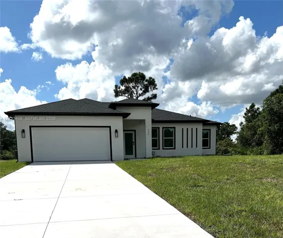 Single-story stucco exterior featuring a hip roof, two-car garage, concrete driveway, and recessed entryway