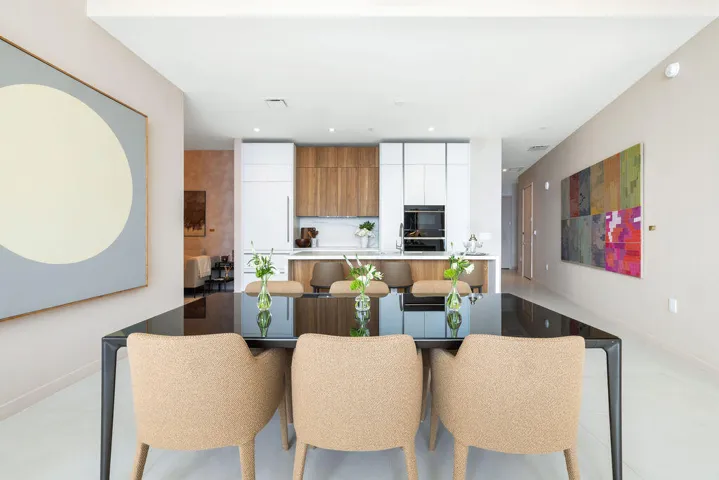 Kitchen featuring floor-to-ceiling cabinetry, wood-finish accents, a peninsula with stone countertop, and built-in appliances