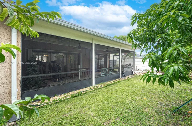 Screen-enclosed patio featuring a solid roof, integrated ceiling fans, and sliding glass door entry