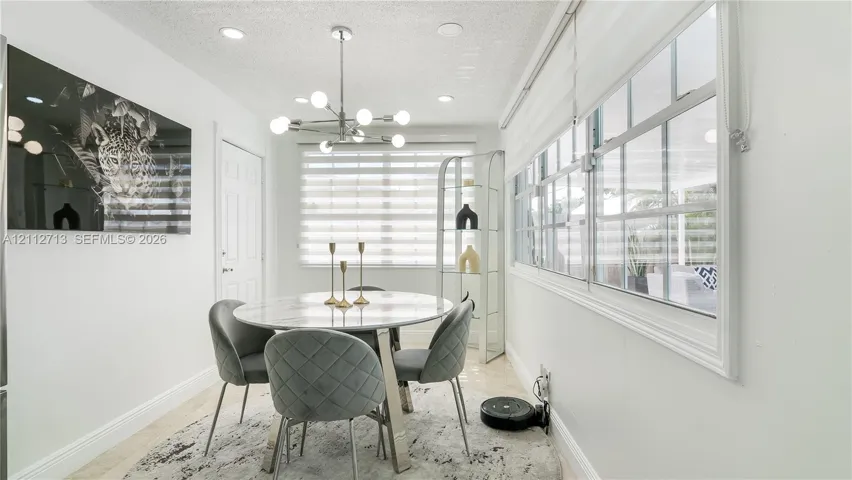 Dining area featuring recessed lighting, a modern multi-bulb chandelier, large windows with horizontal blinds, and tile flooring