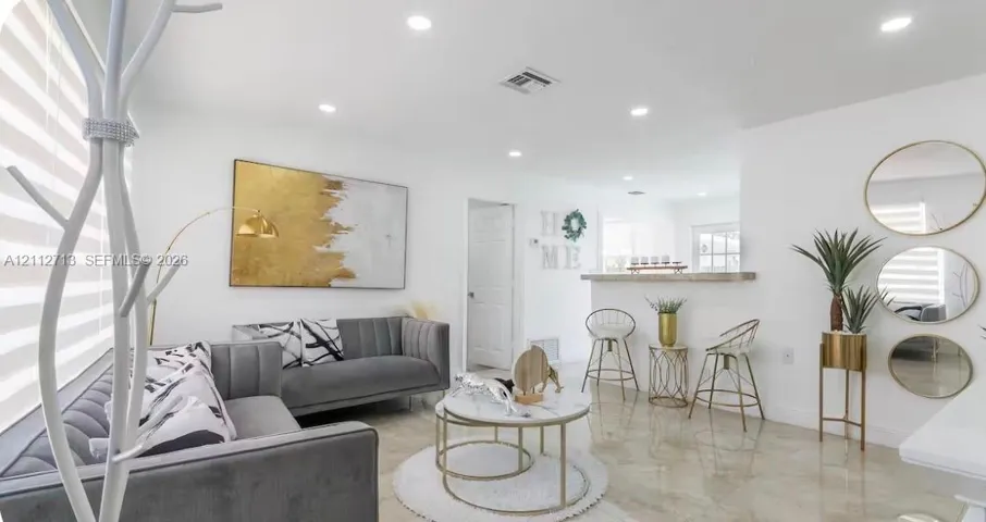 Living area featuring recessed lighting, polished tile flooring, and a breakfast bar with a stone-top counter
