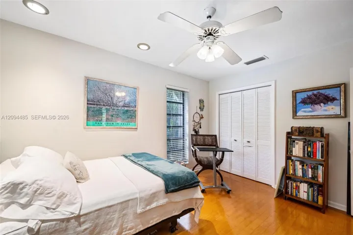 Room featuring wood-finish flooring, recessed lighting, a ceiling fan with integrated lighting, and a closet with white louvered bifold doors