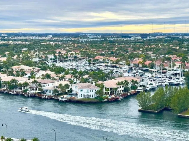 Aerial perspective of waterfront properties featuring deep-water access, private boat docks, paved sea walls, and mature palm landscaping along the canal