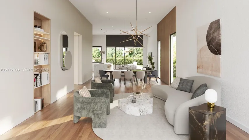Open floor plan featuring wood-finish flooring, recessed lighting, floor-to-ceiling wood-panel accent wall, built-in shelving, and contemporary architectural pendant lighting