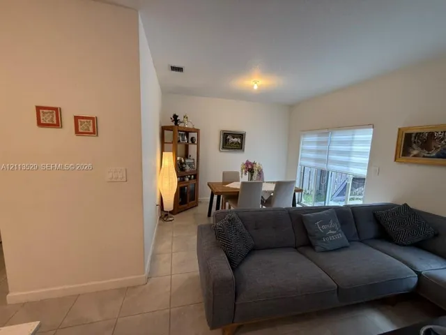 Neutral wall palette, ceramic tile flooring, and a glass sliding door with horizontal privacy blinds