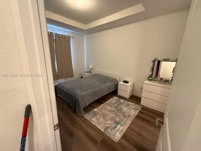Room featuring wood-finish flooring and a recessed tray ceiling