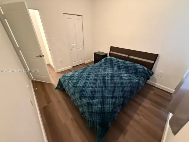 Wood-finish flooring, neutral wall tones, and dual-panel bifold closet doors