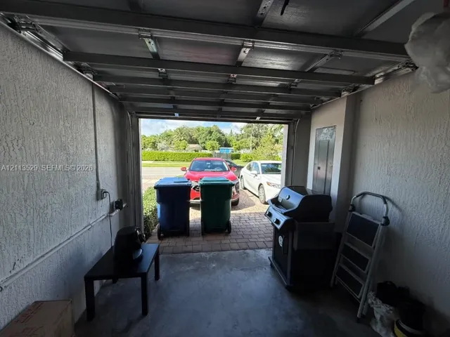Garage interior featuring a concrete floor, textured wall finish, and an electrical breaker panel