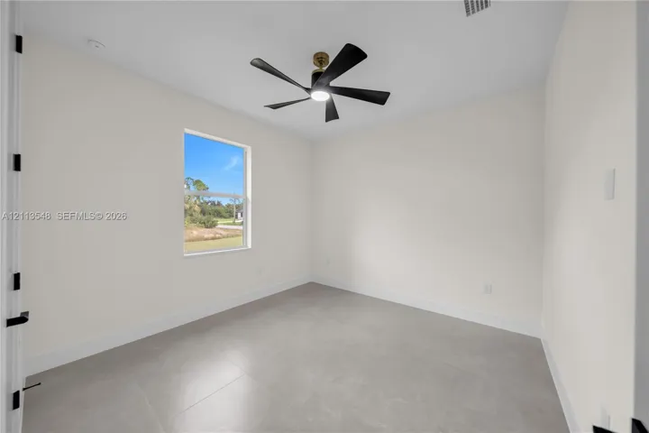 Interior room featuring large-format tile flooring, neutral walls, and a modern ceiling fan with integrated lighting
