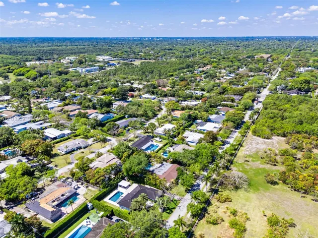 Aerial perspective of the residential grounds featuring mature canopy trees, structured paved street access, and expansive green space