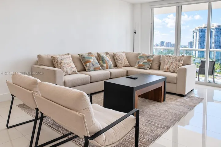 Floor-to-ceiling glass panel windows, polished tile flooring, and a glass-railed balcony