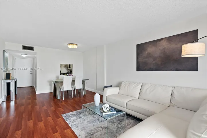 Living area featuring wood-finish flooring, recessed ceiling lighting, and a neutral color palette