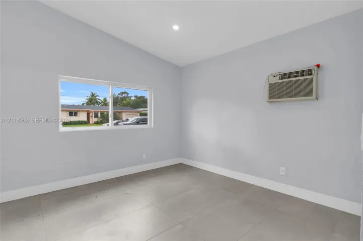 Vaulted ceiling, large-format tile flooring, recessed lighting, and a horizontal sliding window