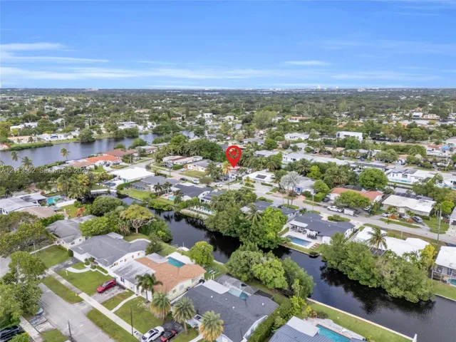 Aerial perspective of a residential lot situated within a waterfront community featuring canal access and mature palm landscaping