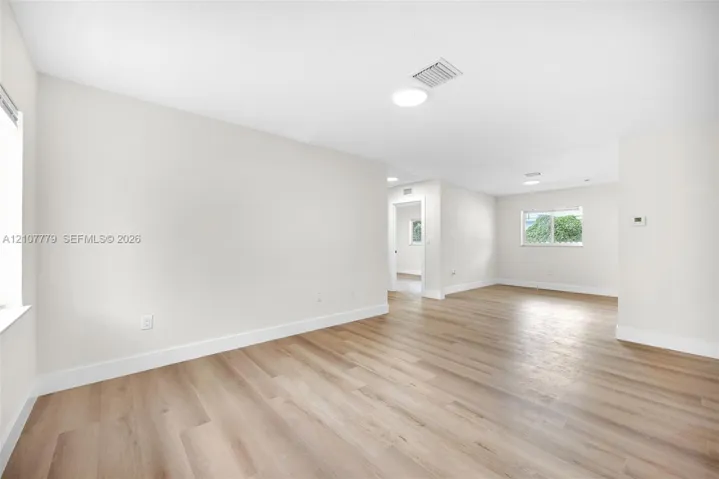Open floor plan with wood-finish flooring, recessed lighting, and crisp neutral wall tones