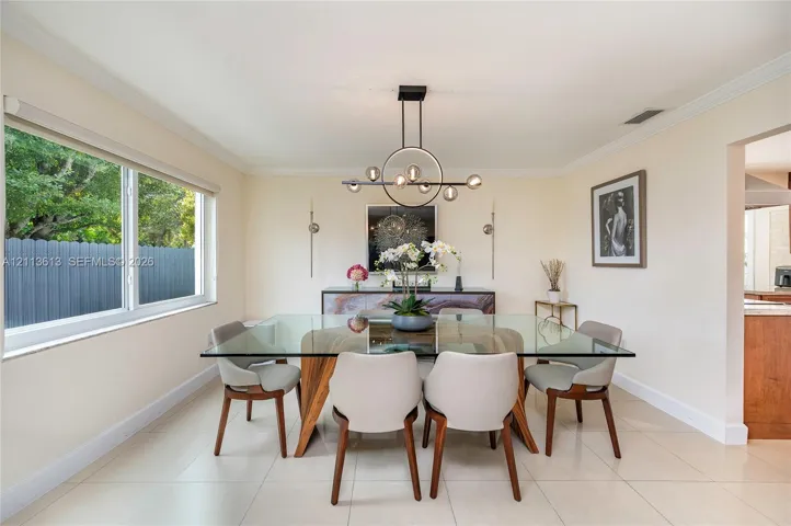 Neutral-toned tile flooring, large horizontal picture window, and a contemporary circular multi-bulb pendant chandelier