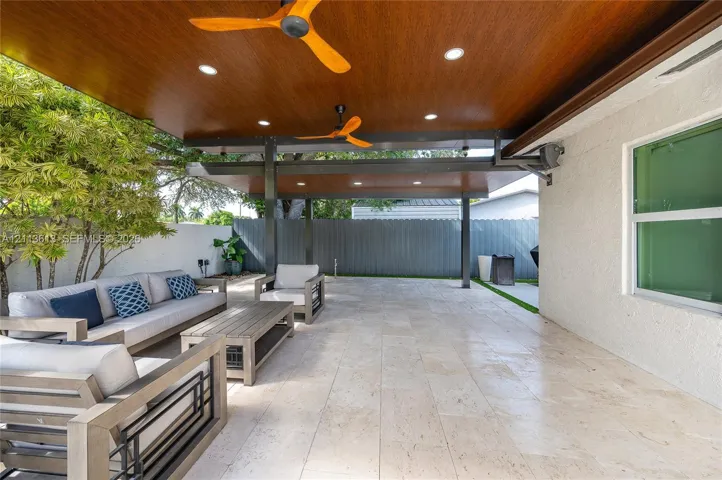 Covered patio featuring a wood-finish ceiling, recessed lighting, dual ceiling fans, metal structural supports, and stone-tile flooring