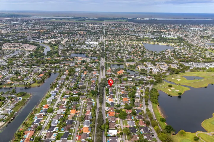 Aerial perspective of a residential neighborhood featuring proximity to lakes and a golf course