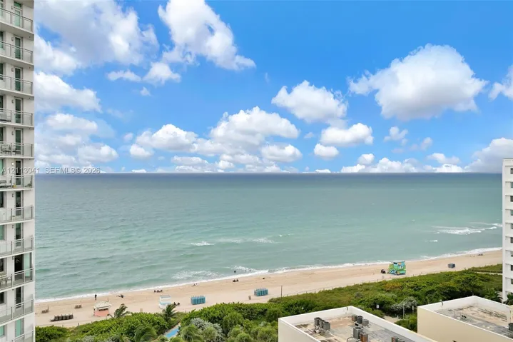 Oceanfront exterior featuring high-rise balconies with glass railings overlooking the coastline