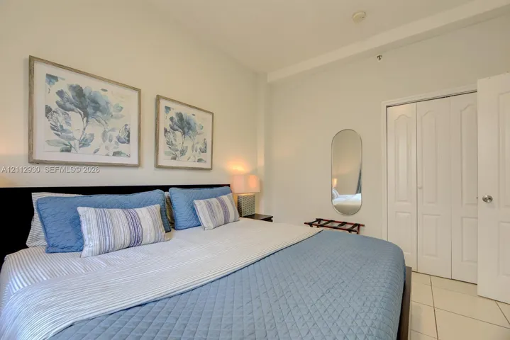 Neutral-toned walls, tile flooring, and a multi-panel closet door