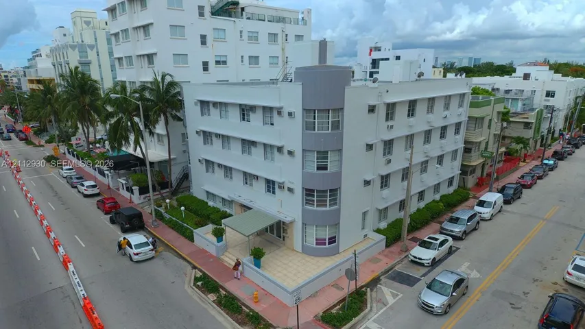 Multi-story Art Deco building featuring a curved corner facade, multi-pane ribbon windows, and a paved street-level entrance