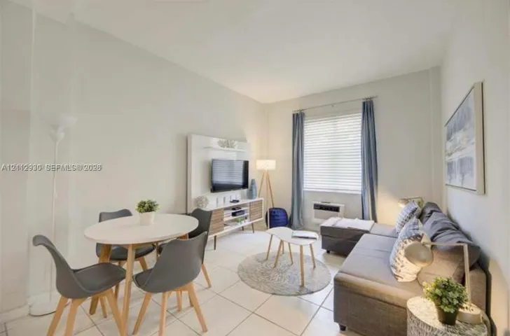 Neutral-toned interior featuring large-format tile flooring and a built-in media console