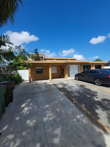 Exterior facade featuring a covered entryway, concrete driveway, horizontal windows, and dual-pane entry door