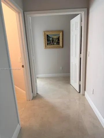 Neutral-toned tile flooring, six-panel interior doors, and neutral wall paint