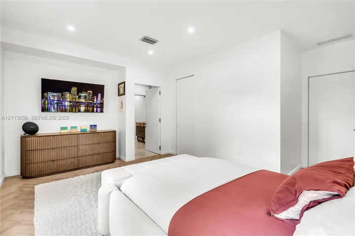 Room featuring herringbone-patterned wood-finish flooring, recessed ceiling lighting, and a recessed wall niche