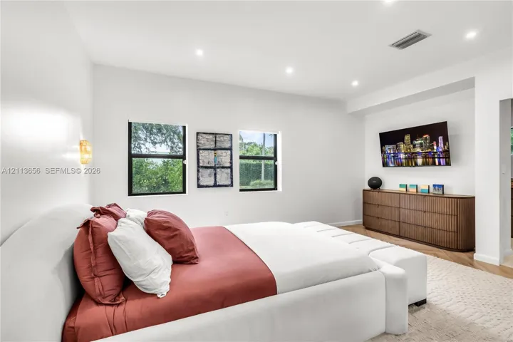 Neutral-toned interior featuring recessed lighting, recessed wall niche, and wood-finish flooring