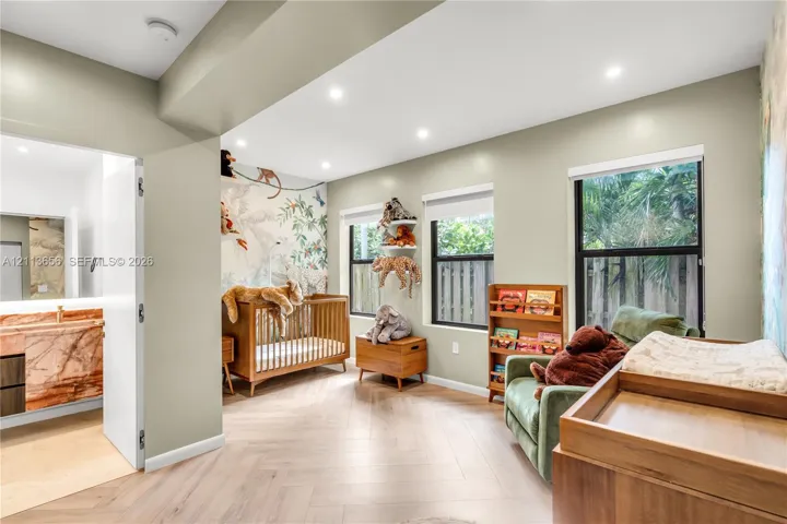 Herringbone-patterned flooring, recessed lighting, and large windows with roller shades