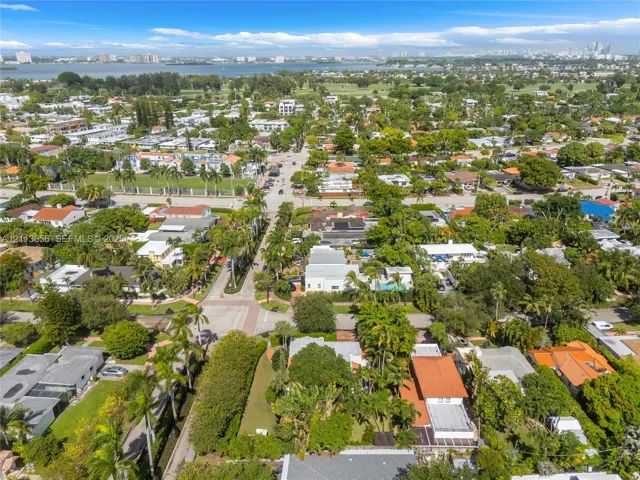 Aerial perspective of a coastal residential neighborhood featuring mature tropical landscaping, dense canopy cover, and proximity to the waterfront