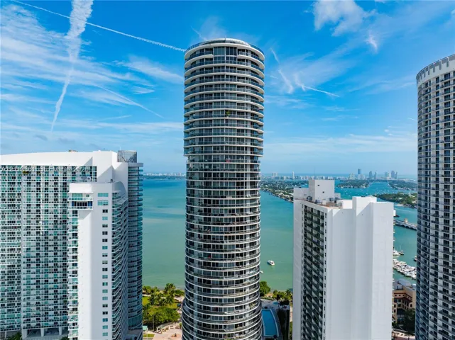 Cylindrical high-rise architecture featuring wraparound balconies and expansive floor-to-ceiling glass windows