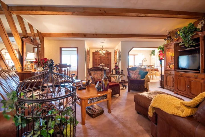 Exposed wood ceiling beams, built-in wooden cabinetry, and wooden interior door frames